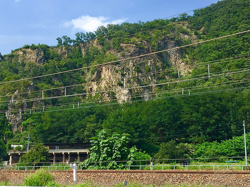 千曲川が削り取った岩山としなの鉄道の写真