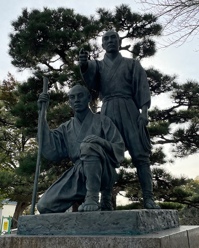 多摩川取水堰に建つ玉川兄弟の像の写真